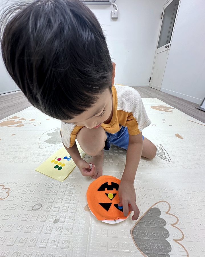 男孩在地墊上做不織布萬聖節面具